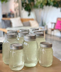 Set of glass jars with metal lids on a wooden surface, blurred indoor background