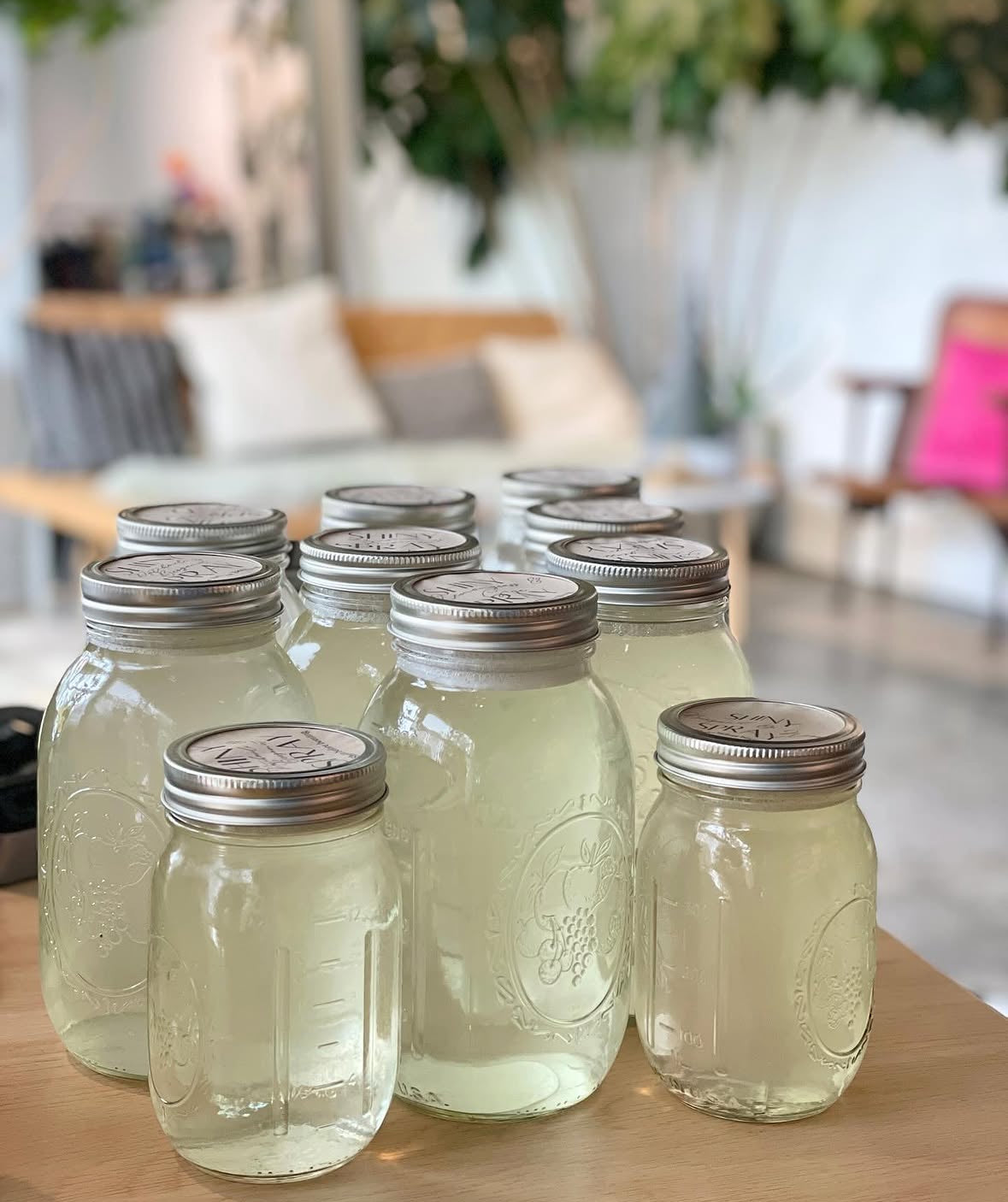 Set of glass jars with metal lids on a wooden surface, blurred indoor background