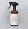 Bottle of Shiny Spray with a label on a white background