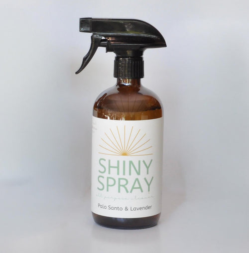 Bottle of Shiny Spray with a label on a white background